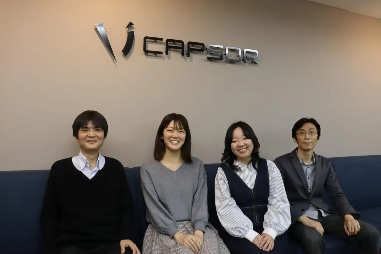 CAPSORのロゴの下、ソファに並んで座るキャプサーの社員4名